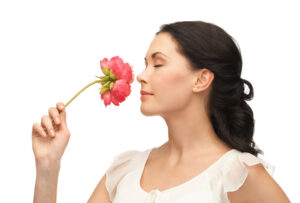 young and beautiful woman smelling flower
